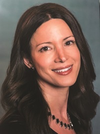 Alexia Rothman, a caucasian woman with long dark hair smiling warmly