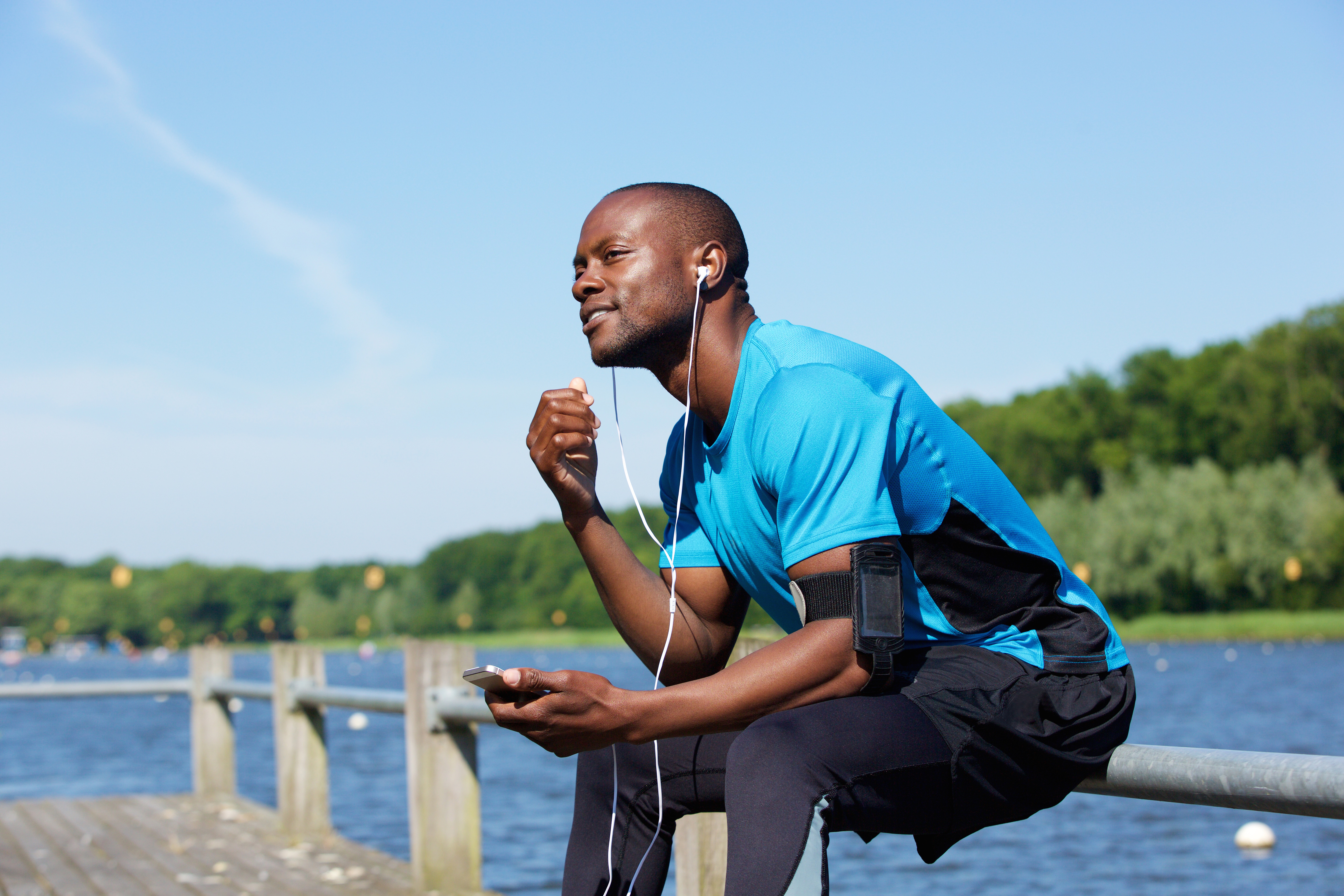 Subscriber listening to an audio edition outdoors on a lakeside dock